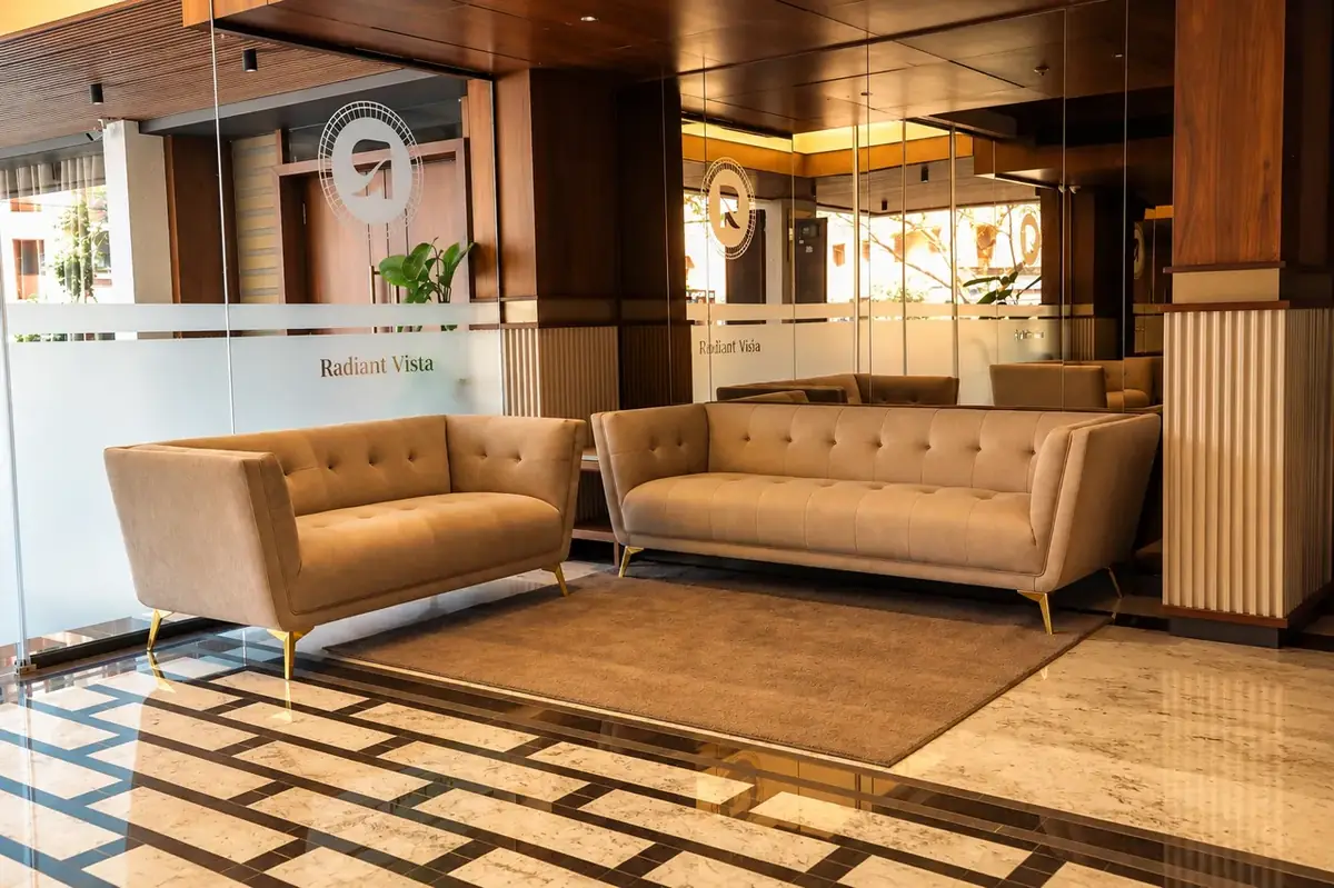 Warm hotel reception lounge and seating area with Radiant Vista emblem at Gokul Road Hubballi
